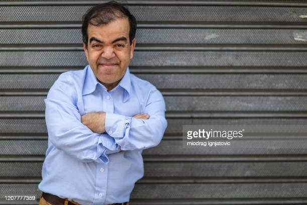short-man-standing-in-front-of-rolling-garage-door.jpg